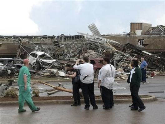 People look at the destruction after a huge tornado struck Moore, Oklahoma May 20, 2013. A huge tornado with winds of up to 200 miles per hour devastated the Oklahoma City suburb of Moore on Monday, ripping up at least two elementary schools and a hospital and leaving a wake of tangled wreckage. At least four people were killed, KFOR television said, citing a reporter’s eyewitness account, and hospitals said dozens of people were injured as the dangerous storm system threatened as many as 10 U.S. states with more twisters. REUTERS/Gene Blevins (UNITED STATES – Tags: ENVIRONMENT DISASTER)