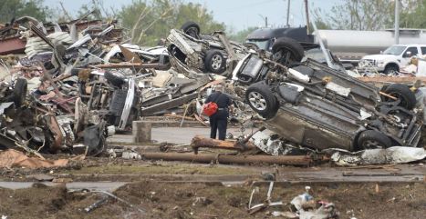 A rescue worker looks for victims in the Moore Hospital parking lot after being hit by a tornado that destroyed buildings and overturned cars in Moore, Oklahoma, near Oklahoma City, May 20, 2013. A huge tornado with winds of up to 200 miles per hour (320 kph) devastated the Oklahoma City suburb of Moore on Monday, ripping up at least two elementary schools and a hospital and leaving a wake of tangled wreckage. At least four people were killed, KFOR television said, citing a reporter’s eyewitness account, and hospitals said dozens of people were injured. REUTERS/Gene Blevins (UNITED STATES – Tags: DISASTER ENVIRONMENT)