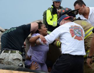 Rescue workers help free one of the 15 people that were trapped at a medical building at the Moore hospital complex after a tornado tore through the area of Moore, Oklahoma May 20, 2013. REUTERS/Gene Blevins (UNITED STATES – Tags: ENVIRONMENT DISASTER TPX IMAGES OF THE DAY
