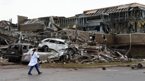 A nurse walks past the destruction at Moore hospital after a huge tornado struck Moore, Oklahoma, near Oklahoma City, May 20, 2013. A huge tornado with winds of up to 200 miles per hour (320 kph) devastated the Oklahoma City suburb of Moore on Monday, ripping up at least two elementary schools and a hospital and leaving a wake of tangled wreckage. REUTERS/Gene Blevins (UNITED STATES – Tags: DISASTER ENVIRONMENT TPX IMAGES OF THE DAY)