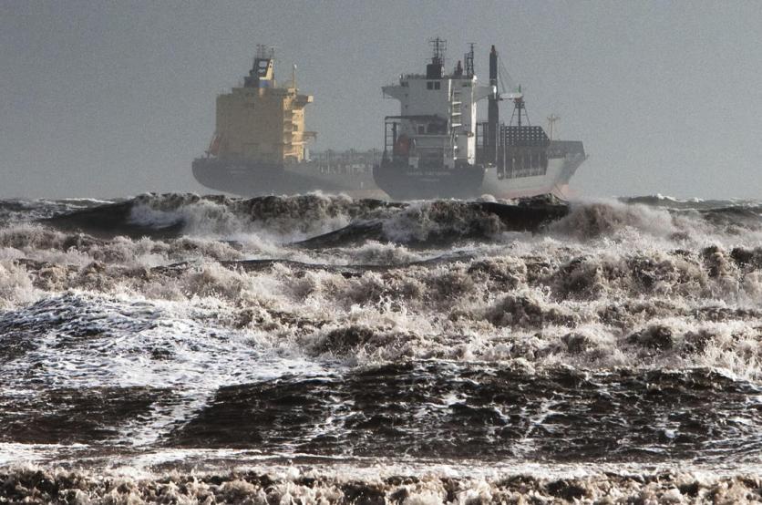 Two tankers are battered by gale winds while at the roadstead in the rough waters of the Gulf of Cagliari, Sardinia, Monday, Nov. 18, 2013. A violent rainstorm that flooded entire parts of the Mediterranean island of Sardinia has led to the deaths of at least nine people. Bridges were felled by swollen rivers and water levels reached 3 metres (yards) in some places. (AP Photo/Max Solinas)