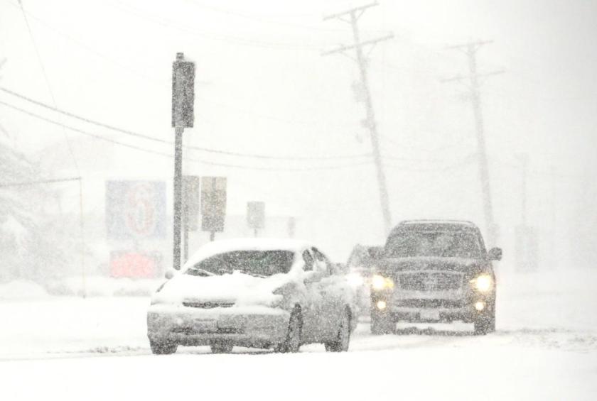 Vehicles move slowly on the road as snow falls Saturday, Nov. 21, 2015, in Wheeling, Ill. The first significant snowstorm of the season blanketed some parts of the Midwest with more than a foot of snow and more was on the way Saturday, creating hazardous travel conditions and flight delays. (AP Photo/Nam Y. Huh)